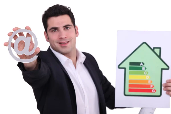 Arquitecto sosteniendo en el cartel y la imagen que muestra la casa con calificación de energía — Foto de Stock
