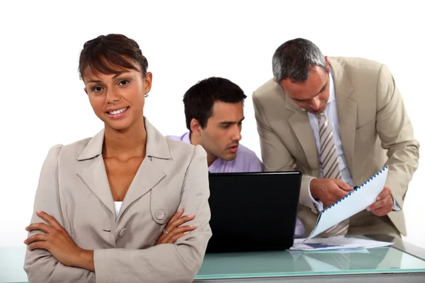 Leende affärskvinna står framför manliga kolleger — Stockfoto