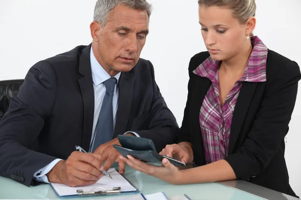 Empresário e mulher usando uma calculadora — Fotografia de Stock