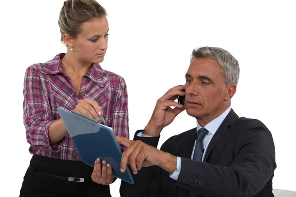 Uomo che fa una telefonata d'affari con l'aiuto della sua segretaria — Foto Stock