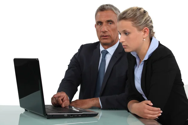 Um casal de empresários discutindo sobre um laptop . — Fotografia de Stock