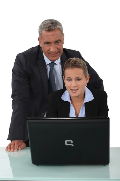 Businessman and a young businesswoman at a laptop — Stock Photo, Image