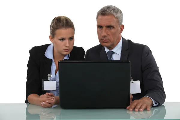 Arbetarna bär märke framför en dator — Stockfoto