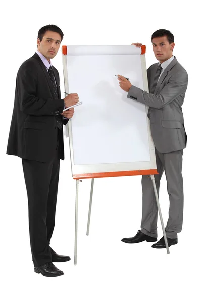 Two businessmen running through financial results — Stock Photo, Image
