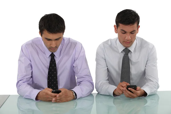 Empresarios que envían mensajes de texto simultáneamente —  Fotos de Stock