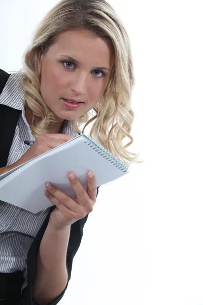 Blonde Büroangestellte schreibt auf Notizblock — Stockfoto