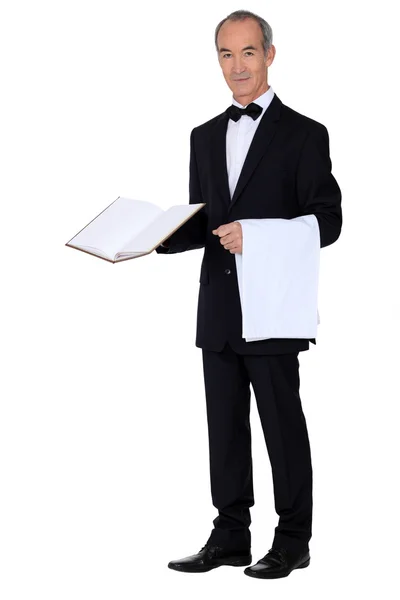 Grey haired waiter holding menu and table cloth — Stock Photo, Image