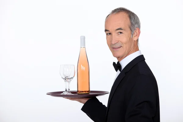 Servitör med vin på bricka — Stockfoto