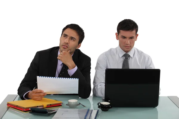 Male colleagues working side by side Royalty Free Stock Images