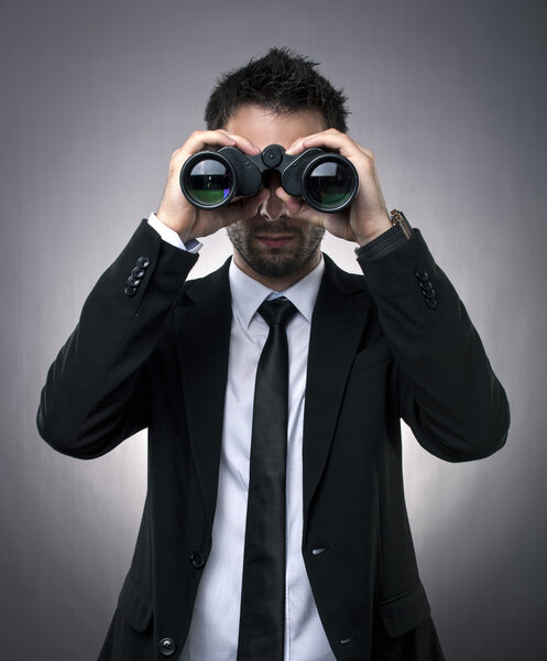 Businessman looking through binoculars