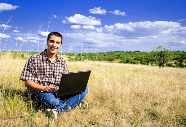 Smiling man with his laptop — Stock Photo, Image
