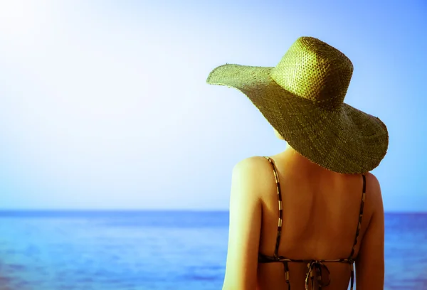 Frau mit grünem Hut steht am Meer — Stockfoto