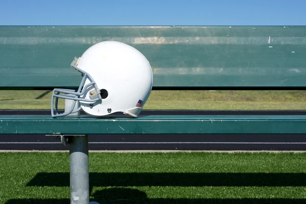 Американский футбольный шлем на скамейке — стоковое фото