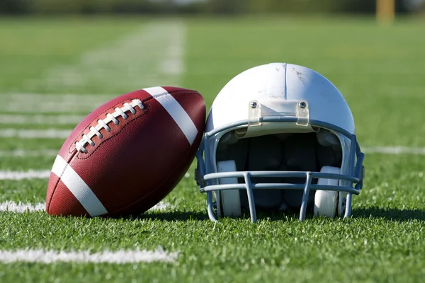 Американский футбол и шлем на поле — стоковое фото