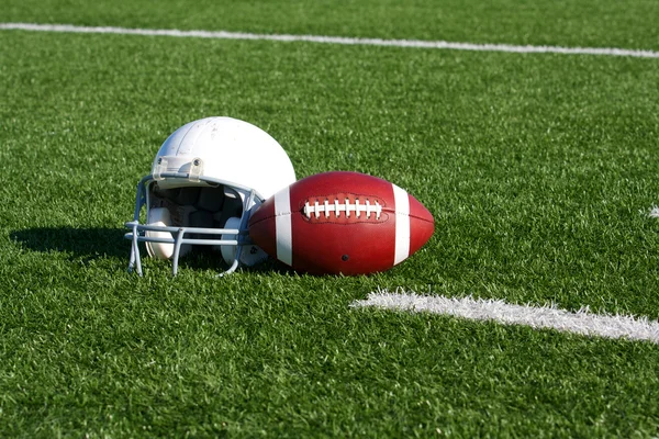 Fußball und Helm auf dem Spielfeld — Stockfoto