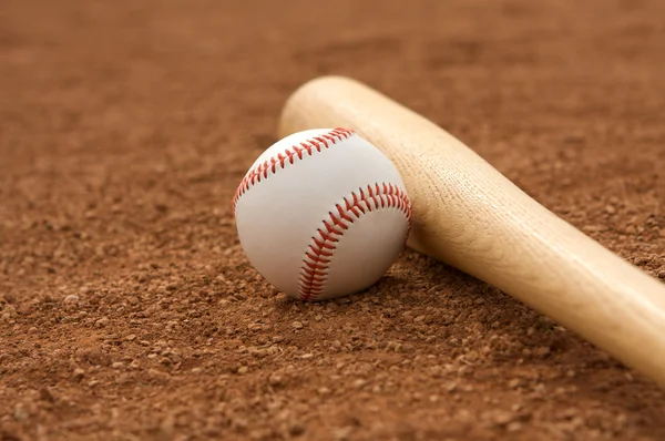 Бейсбол и бита в Инфилде — стоковое фото