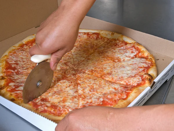 Cutting the pizza pie with a rolling cutter — Stock Photo, Image