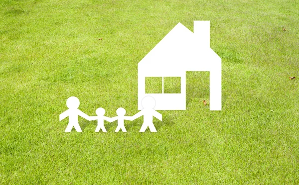 Familienhaus aus Papier geschnitten auf Gras Hintergrund — Stockfoto