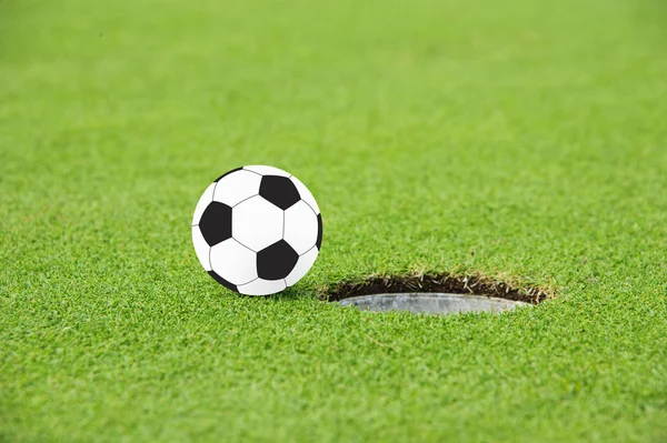 Fotboll på kanten av hål — Stockfoto