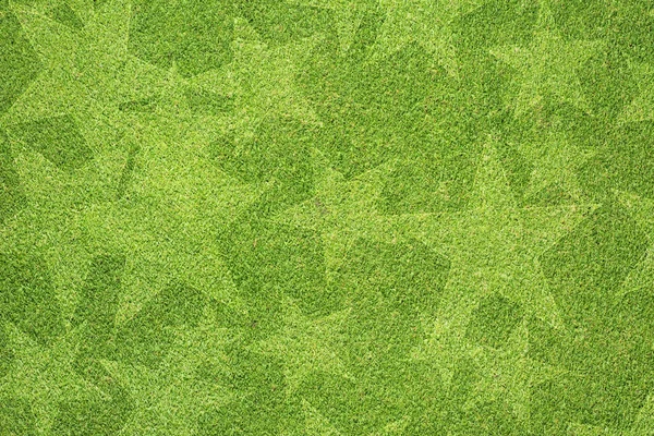 Estrela na textura de grama verde e fundo — Fotografia de Stock