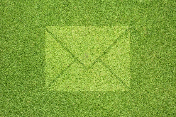 Email icon on green grass texture and background — Stock Photo, Image