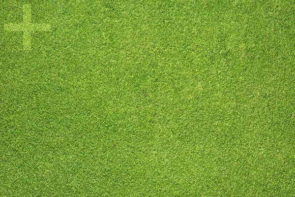 Plus icon on green grass background — Stock Photo, Image