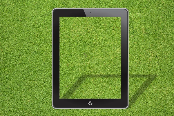 Tablet computer on green grass background — Stock Photo, Image