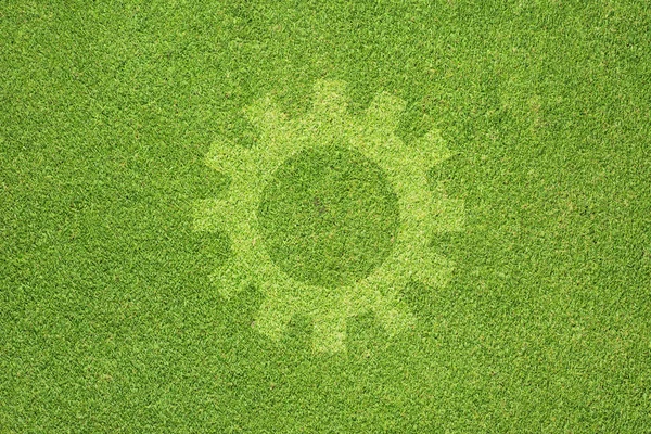 Ícone de engrenagem no fundo de grama verde — Fotografia de Stock