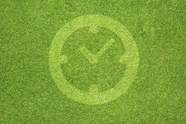 Klokpictogram op groen gras textuur en achtergrond — Stockfoto