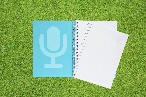 Microphone with music on grass background — Stock Photo, Image