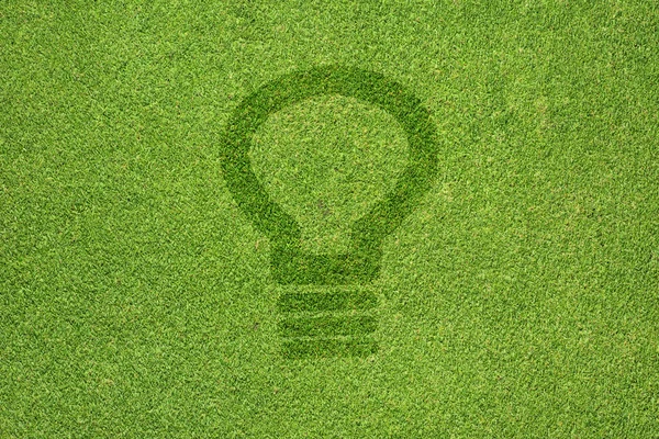 Icono de luz de bombilla sobre hierba verde textura y fondo —  Fotos de Stock