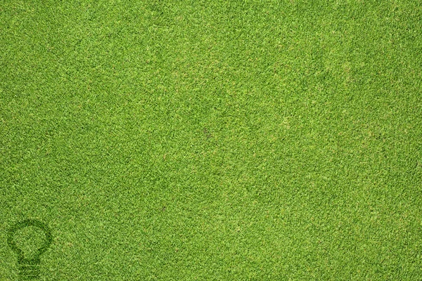 Ampul Işık simgesi yeşil çim doku ve arka plan — Stok fotoğraf