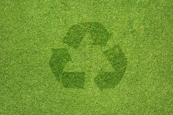 Recycling-Symbol auf grünem Gras Textur und Hintergrund — Stockfoto
