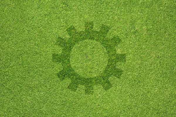 Gear icon on green grass texture and background — Stock Photo, Image