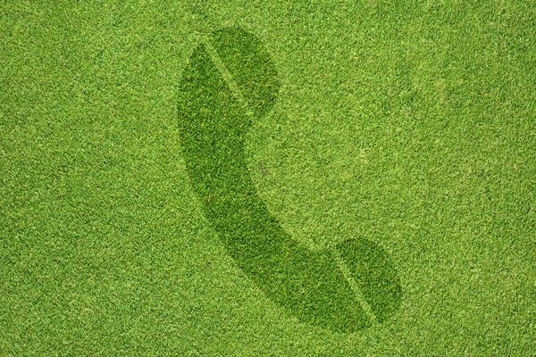 Phone icon on green grass texture and background — Stock Photo, Image