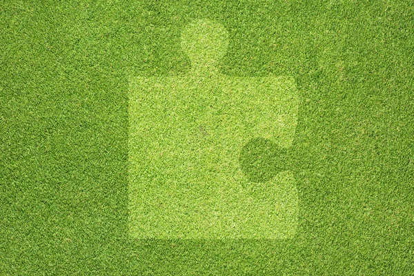 Puzzle na zielonej trawie tekstury i tła — Zdjęcie stockowe