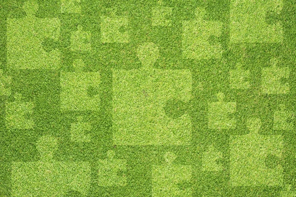 Puzzel op groen gras textuur en achtergrond — Stockfoto