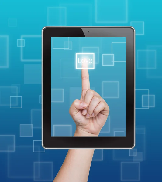 Botão de amor mão empurrando de tablet em uma tela sensível ao toque — Fotografia de Stock