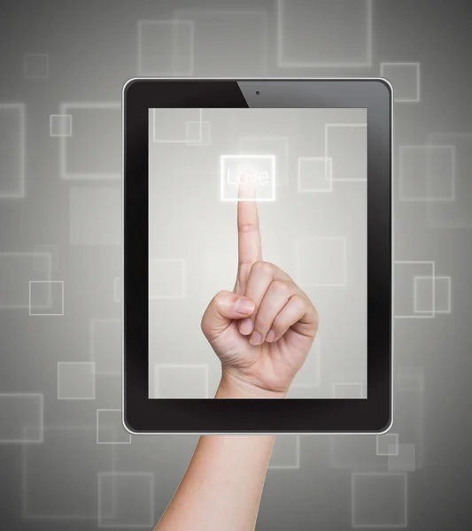Hand duwen liefde knop van de Tablet PC op een touchscreen — Stockfoto