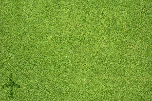 Значок самолета на зеленой текстуре травы и фоне — стоковое фото