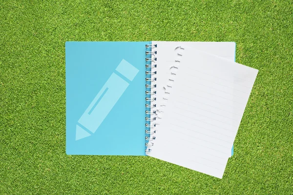 Livro com lápis ícone no fundo da grama — Fotografia de Stock