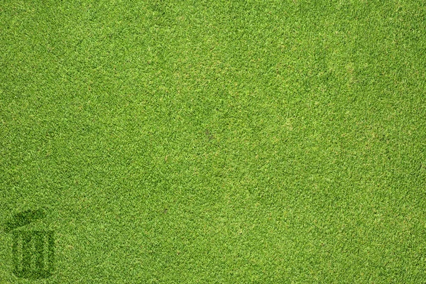 Значок мусора на зеленой текстуре травы и фоне — стоковое фото