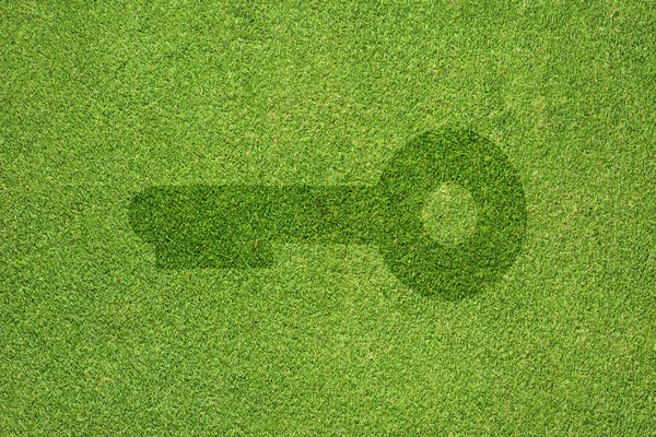 Key icon on green grass texture and background — Stock Photo, Image