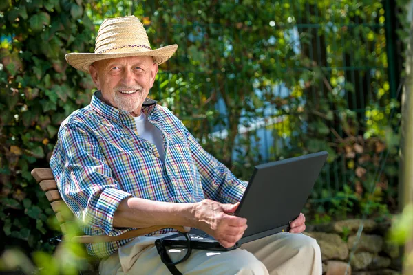 Senior med en bärbar dator — Stockfoto