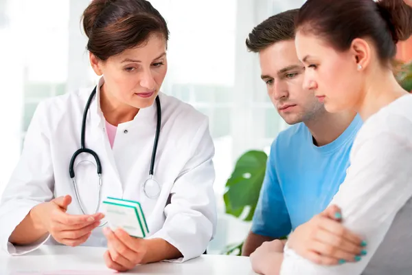 Doctor consults a young couple Stock Image