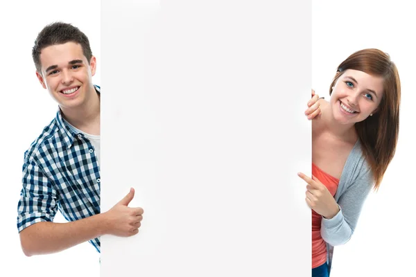 Adolescentes sonrientes sosteniendo en un tablero en blanco —  Fotos de Stock