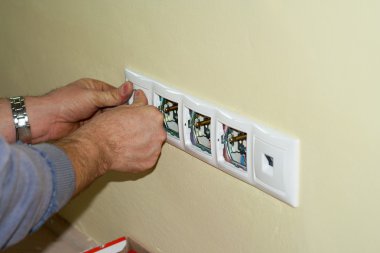 Electrician completes the socket at 230 volts clipart