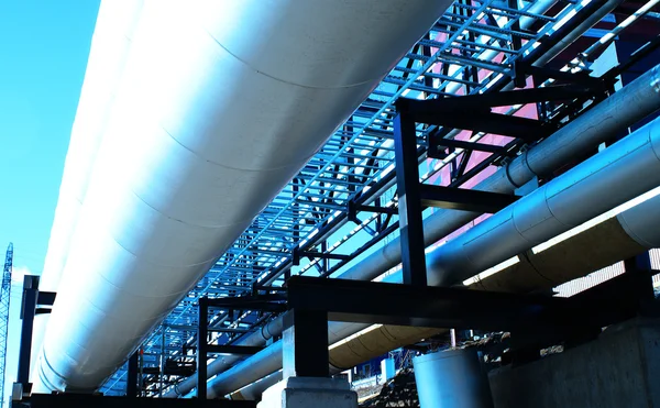 Zona industrial, dutos de aço e válvulas contra o céu azul — Fotografia de Stock