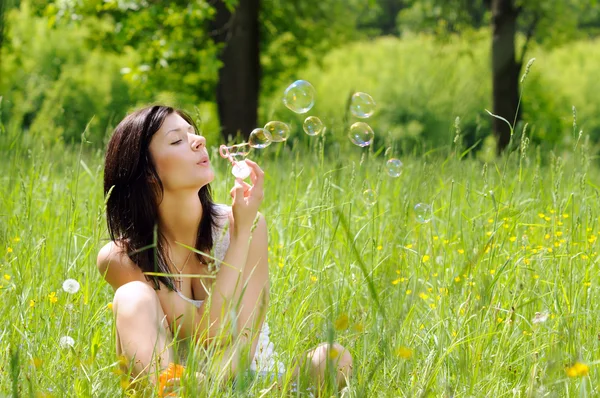 Girl inflating soap bubbles — Stock Photo, Image