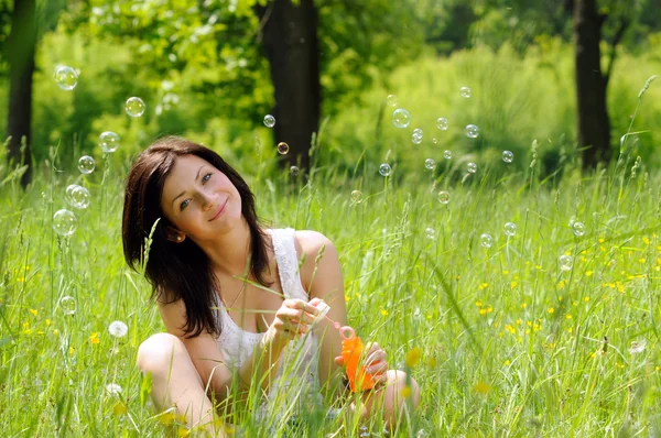 Girl inflating soap bubbles — Stock Photo, Image